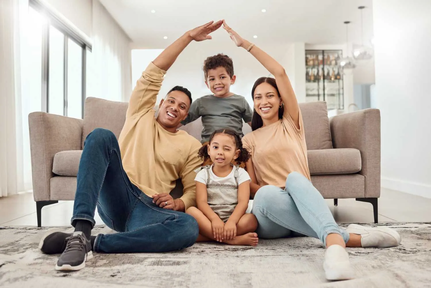 Family at home under a roof shape made with their hands